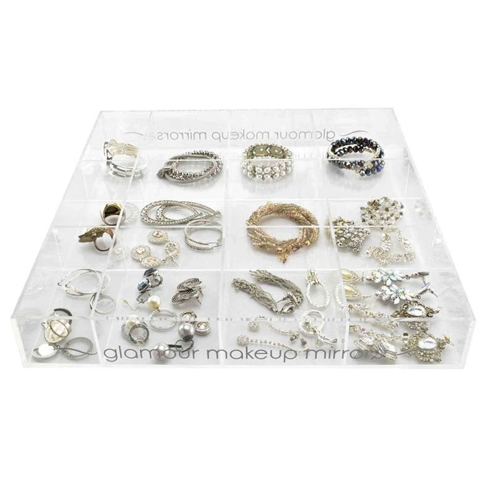 The UNIQ Acrylic Organiser Tray for makeup or jewellery features 12 compartments, ideal for neatly arranging silver and gold rings, earrings, and bracelets—perfect stylish storage by UNIQ.