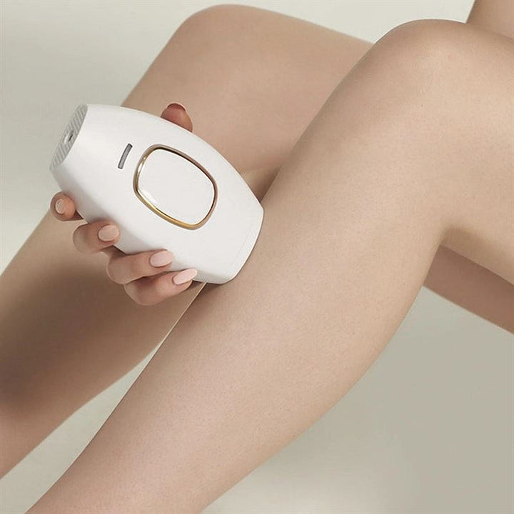 A person uses the UNIQ IPL Hair Removal Device on their lower leg for smooth, pain-free permanent hair reduction at home; their skin looks smooth against a light, neutral background.